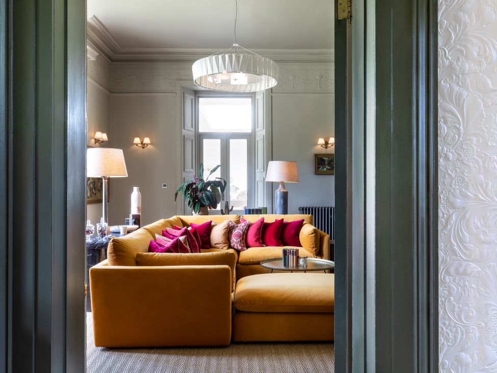 A living room with a yellow sofa and a lamp at The Country House Cumbria Castle Carrock