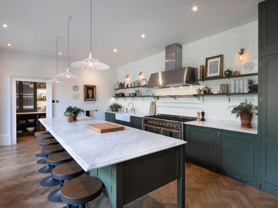 A kitchen with an island and stools at The Country House Cumbria Castle Carrock