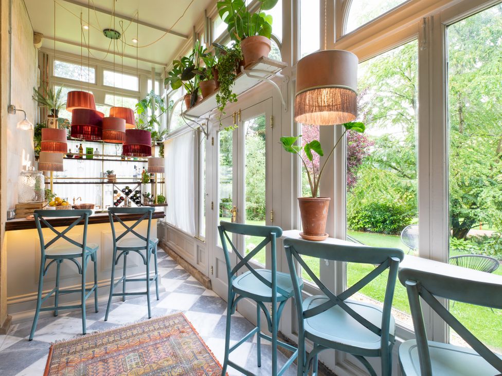 A kitchen with a bar and stools at The Country House Cumbria, Castle Carrock