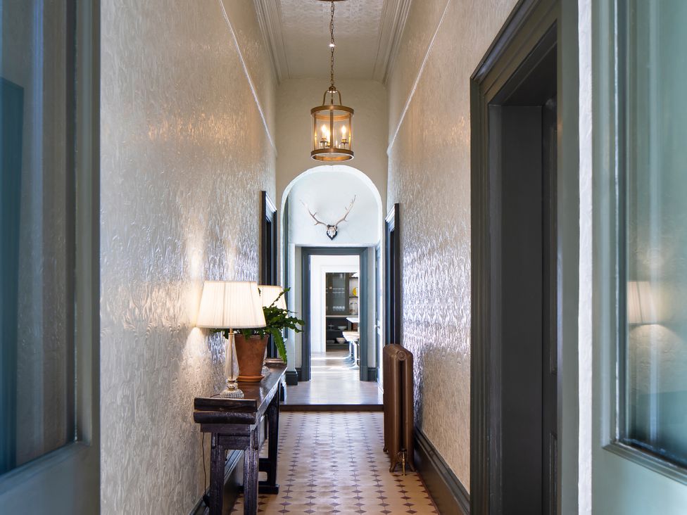 A hallway with a table and lamp at The Country House Cumbria in Castle Carrock