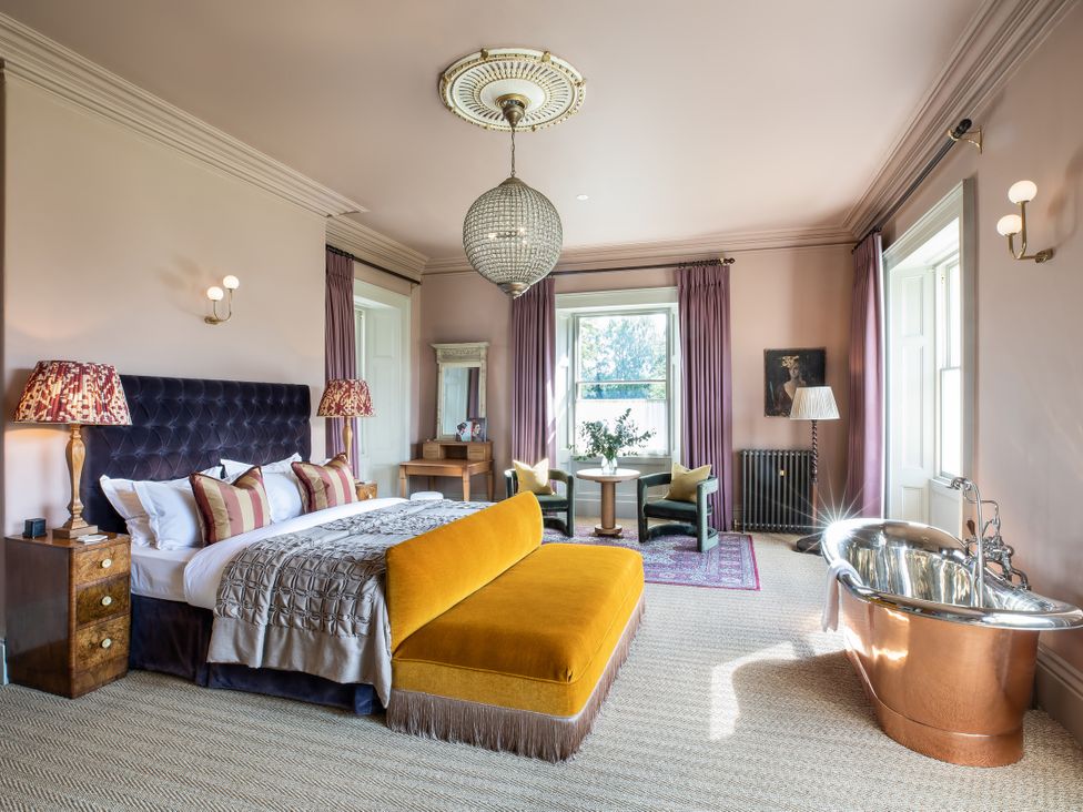 A bedroom with a bed, sofa, and a bathtub at The Country House Cumbria Castle Carrock