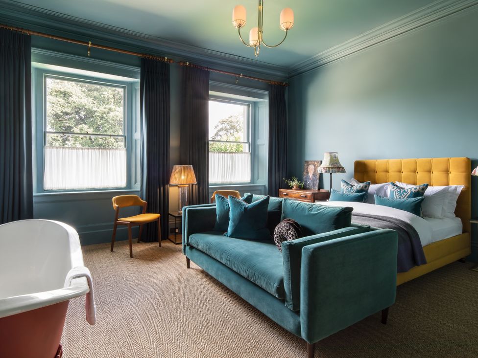 A bedroom with a bed and sofa at The Country House Cumbria Castle Carrock