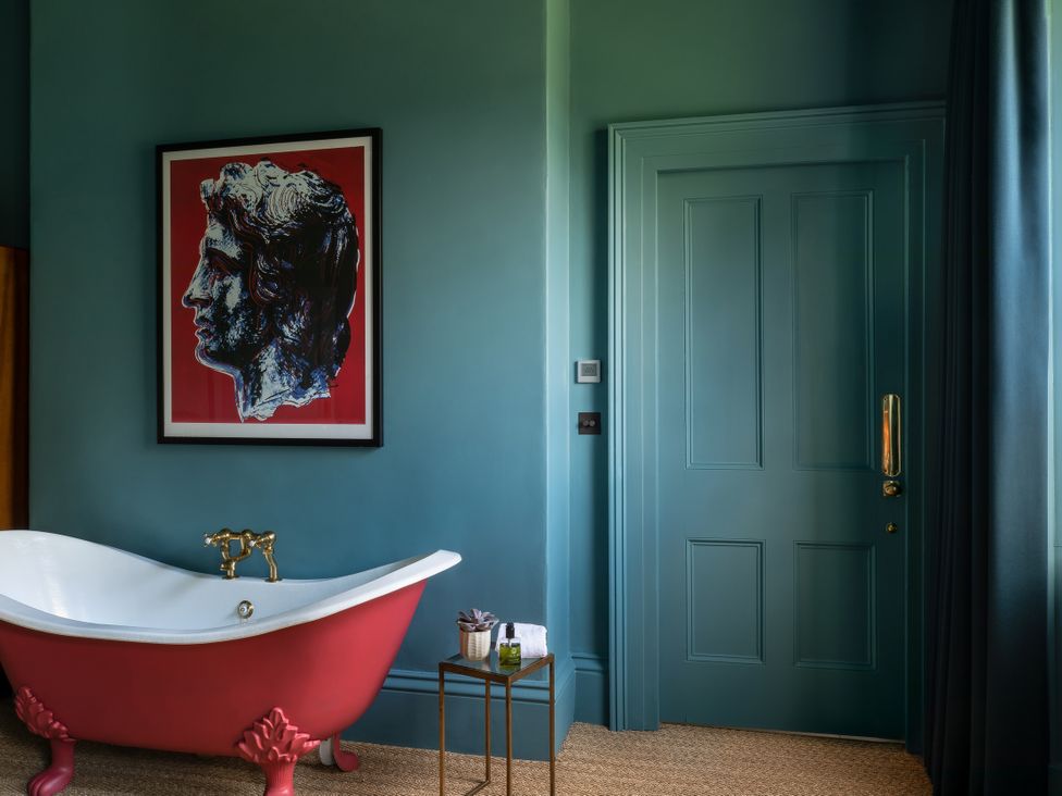 A bathroom with a bathtub near a door at The Country House Cumbria in Castle Carrock