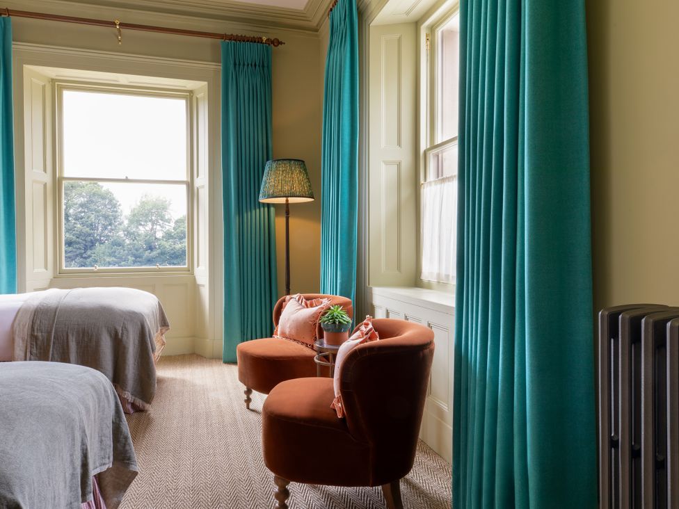 A bedroom with two beds and a seating area at The Country House Cumbria in Castle Carrock