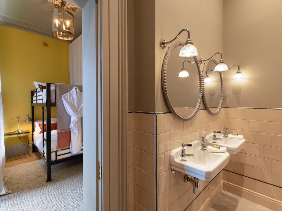 A bathroom with dual sinks and mirrors at The Country House Cumbria in Castle Carrock