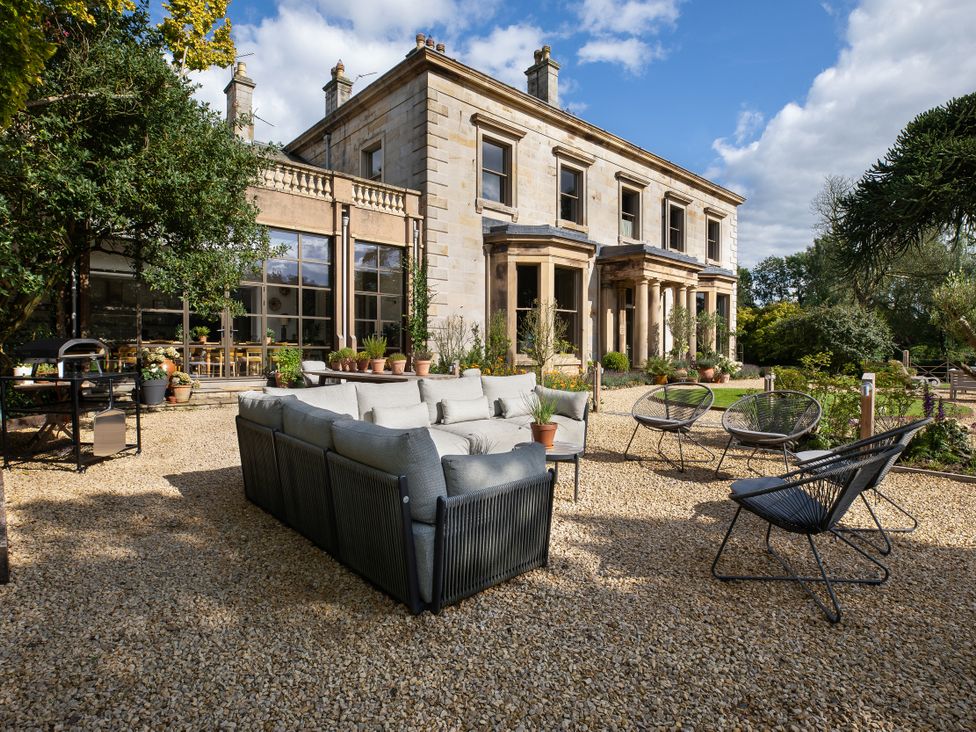 A garden with a sofa and chairs at The Country House Cumbria Castle Carrock