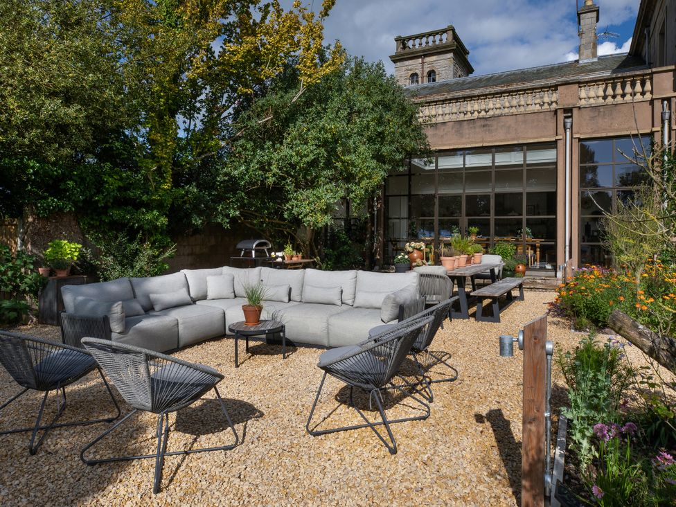 An outdoor seating area with a couch and chairs at The Country House Cumbria Castle Carrock