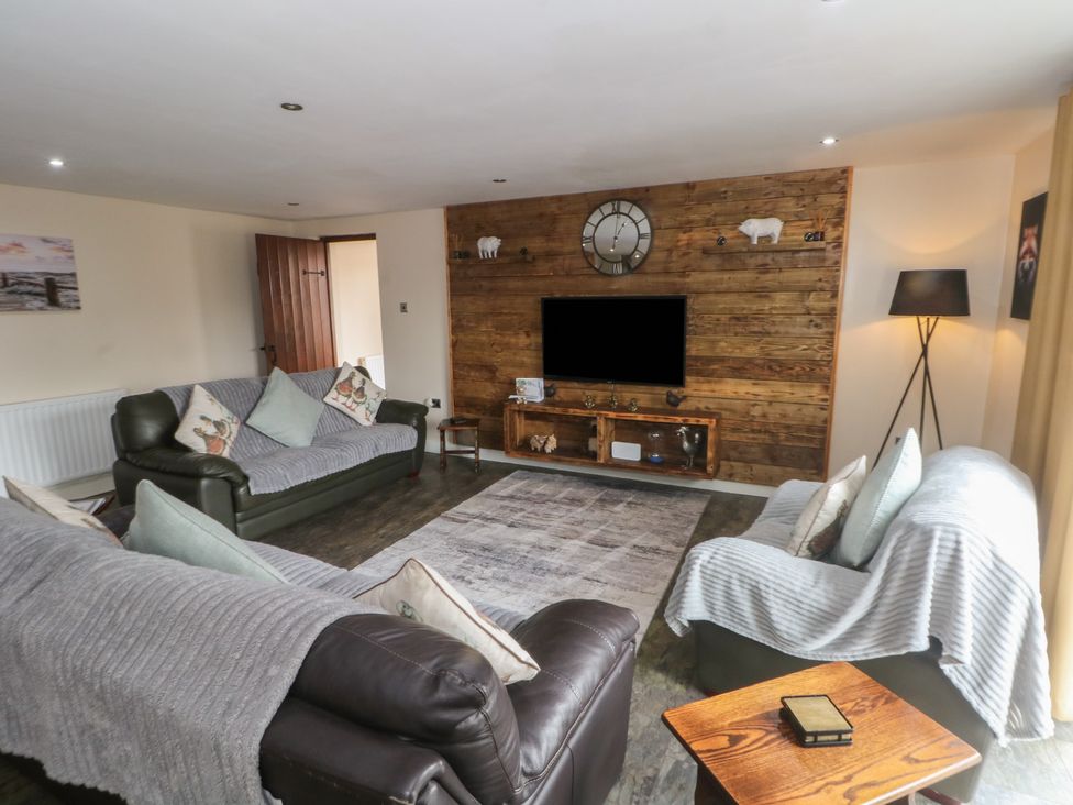 A living room with sofas and a television at Pompian Lodge in Leyland