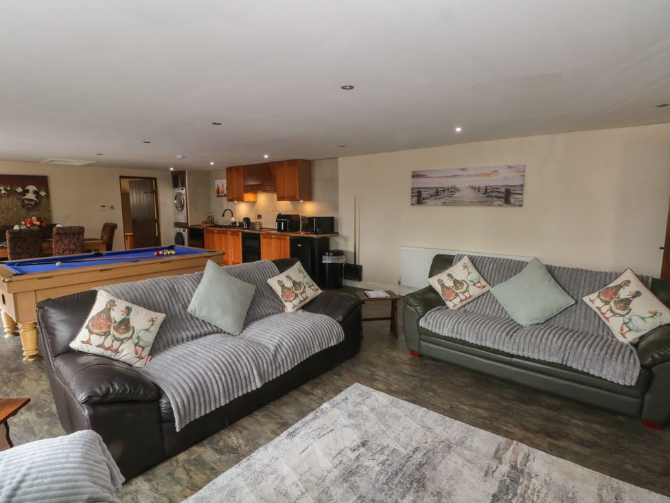 A living room with a pool table and sofas at Pompian Lodge in Leyland