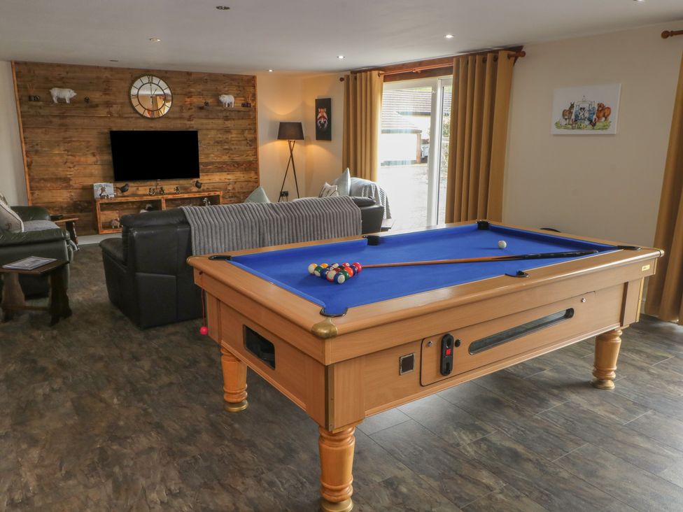 A game room with a pool table and sofa at Pompian Lodge in Leyland