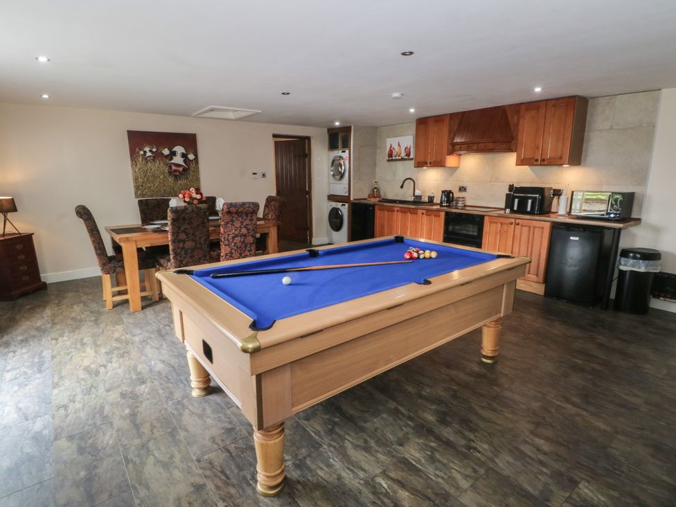 A games room with a pool table and kitchen amenities at Pompian Lodge in Leyland