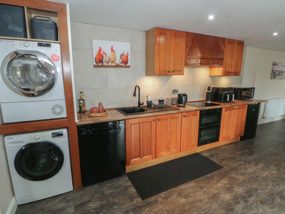 A kitchen featuring appliances and wooden cabinets at Pompian Lodge Leyland