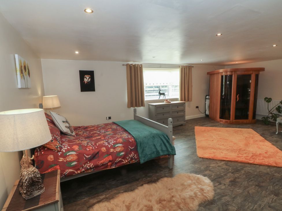 A bedroom with a bed and a sauna at Pompian Lodge in Leyland