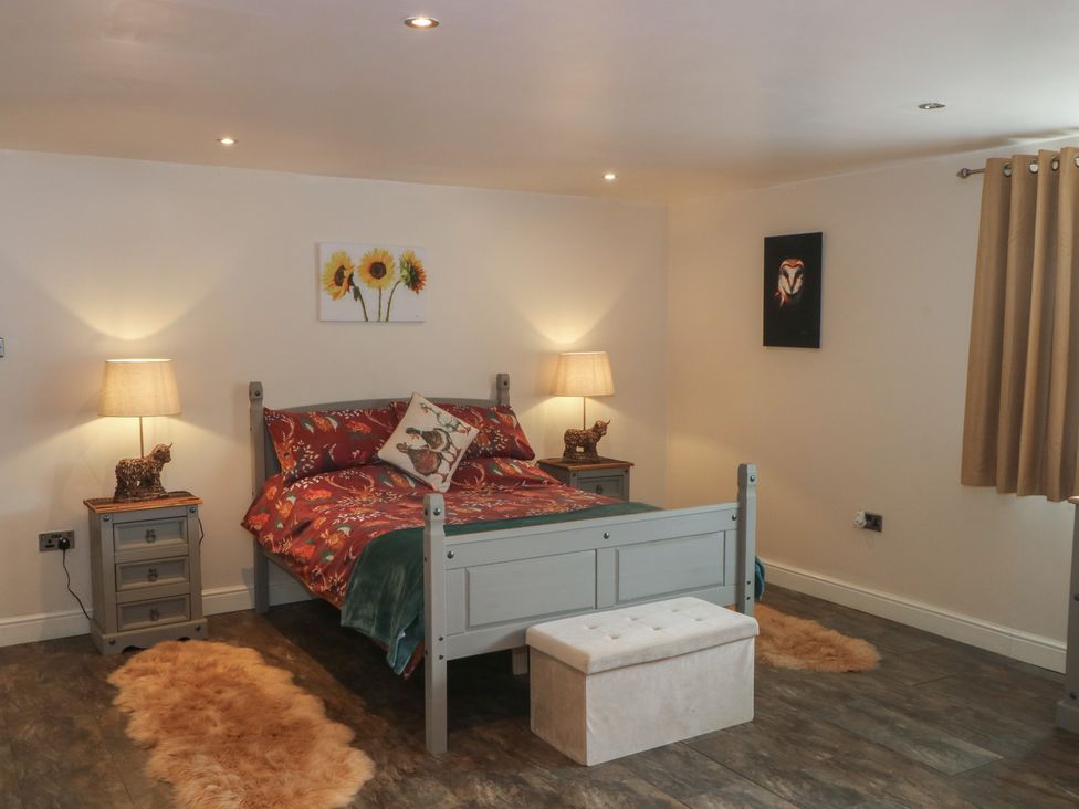 A bedroom with a bed and bedside tables at Pompian Lodge in Leyland