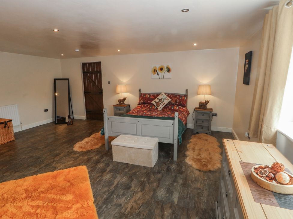 A bedroom with a bed and nightstand at Pompian Lodge Leyland
