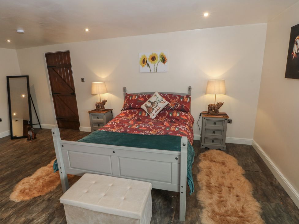 A bedroom with a bed and nightstand at Pompian Lodge in Leyland