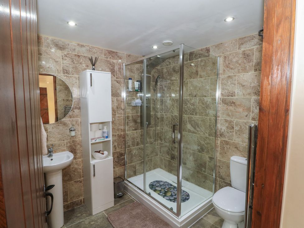 A bathroom with a shower, toilet, sink, and storage at Pompian Lodge Leyland
