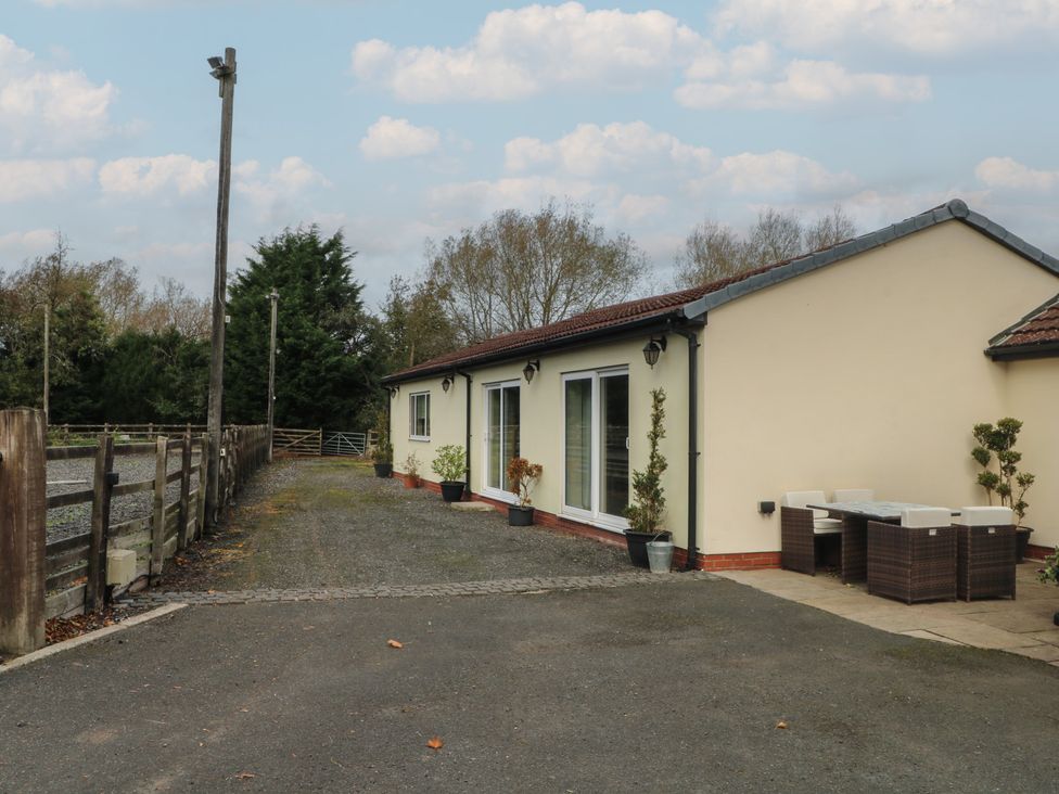 An outdoor area with a building, table, and chairs at Pompian Lodge Leyland