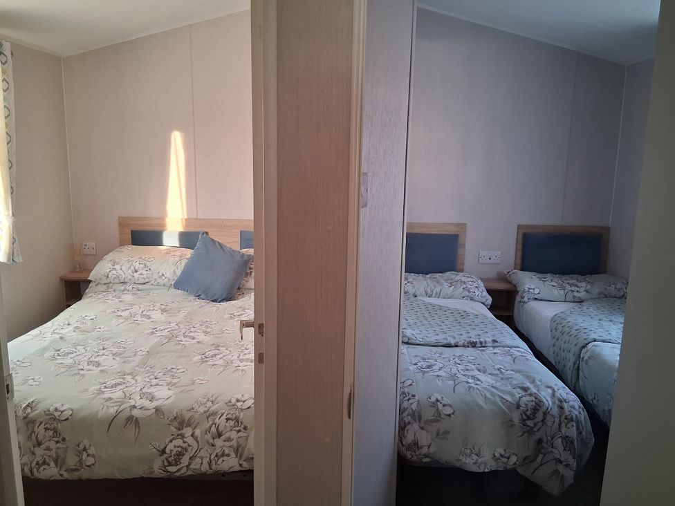 A bedroom with a double and twin bed at Willerby Malton 2023 in Kidwelly