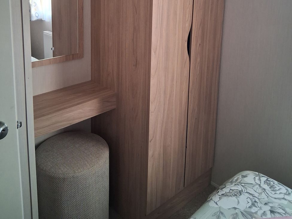 A bedroom with a wardrobe, mirror, bench and stool at Willerby Malton 2023 in Kidwelly