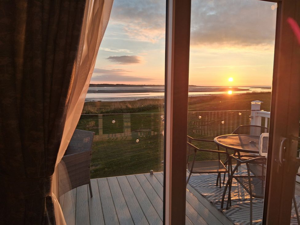 A view from a glass door showing a sunset over a landscape at Willerby Malton 2023 in Kidwelly