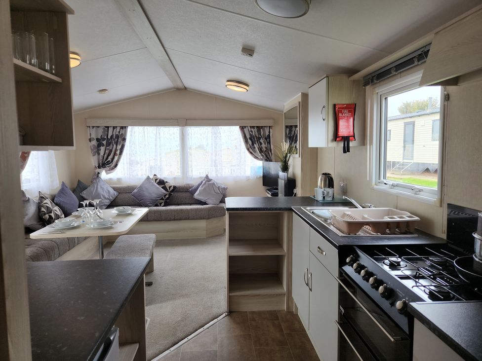 A living room with a couch and kitchen area at 123 Elms