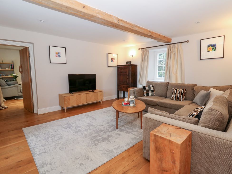A living room with a sofa and television at Secret Garden Cottage in Ciliau Aeron near Aberaeron