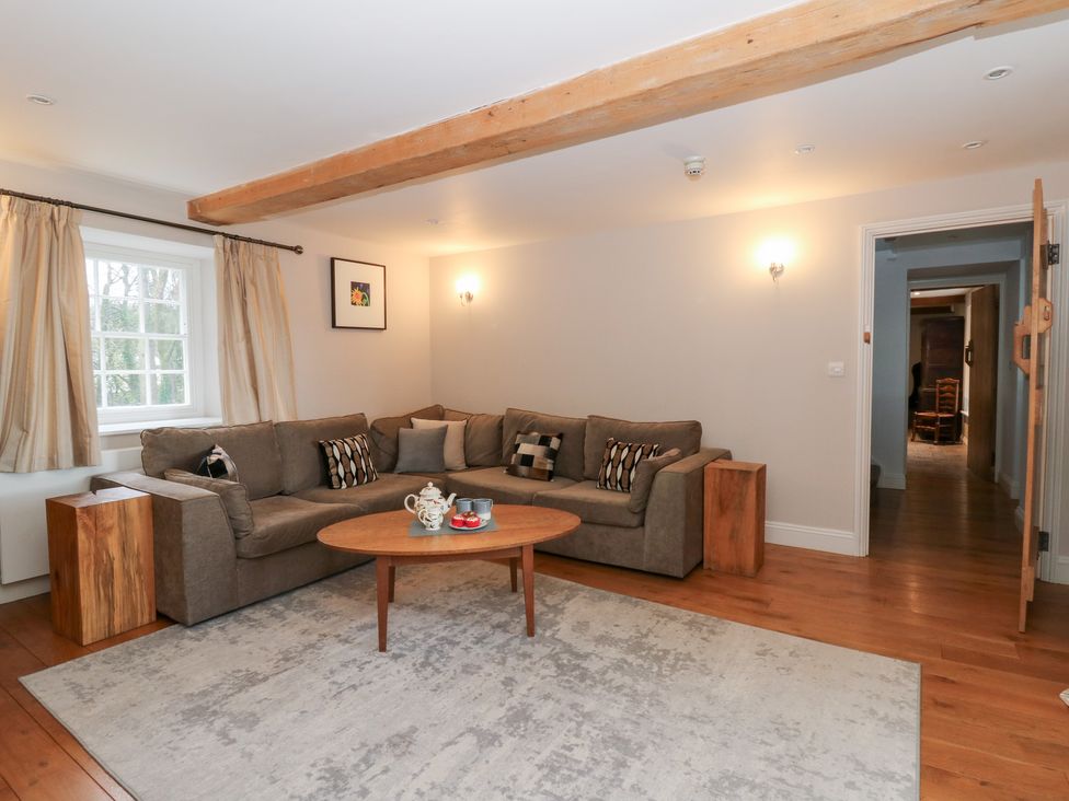 A living room with a sofa and coffee table at Secret Garden Cottage in Ciliau Aeron near Aberaeron