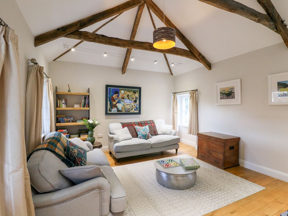 A living room with a sofa and coffee table at Secret Garden Cottage in Ciliau Aeron near Aberaeron