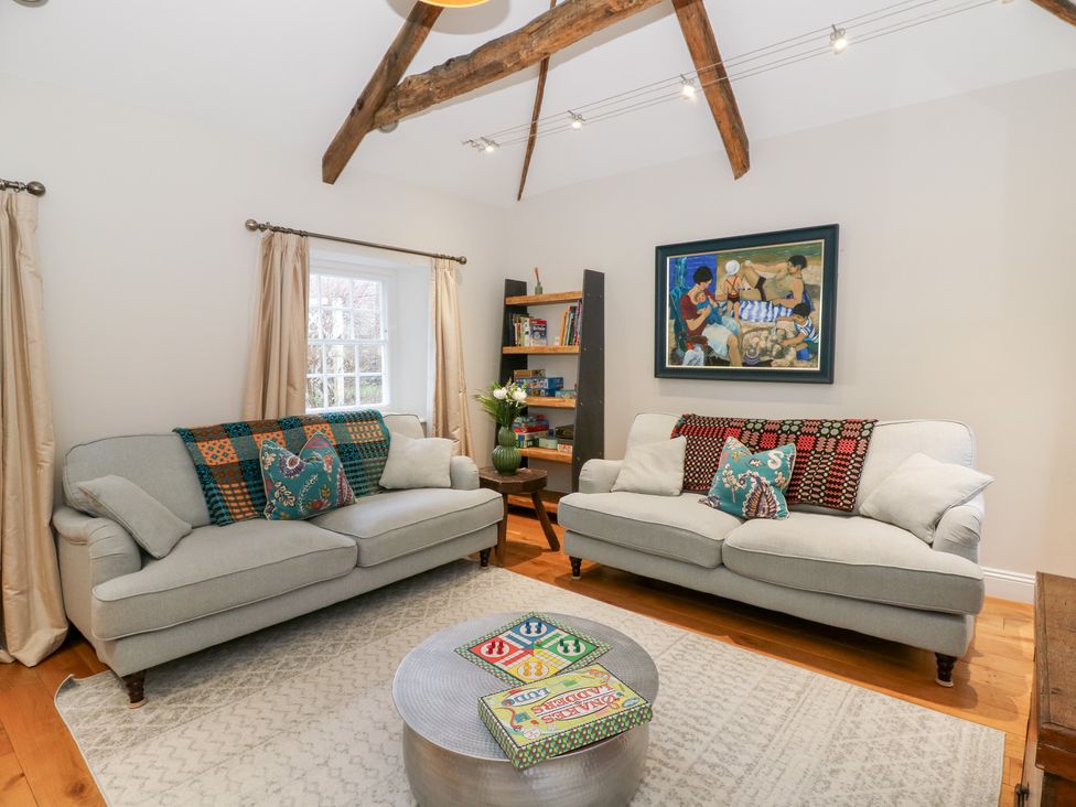 A living room with sofas and a shelf in Secret Garden Cottage Ciliau Aeron near Aberaeron