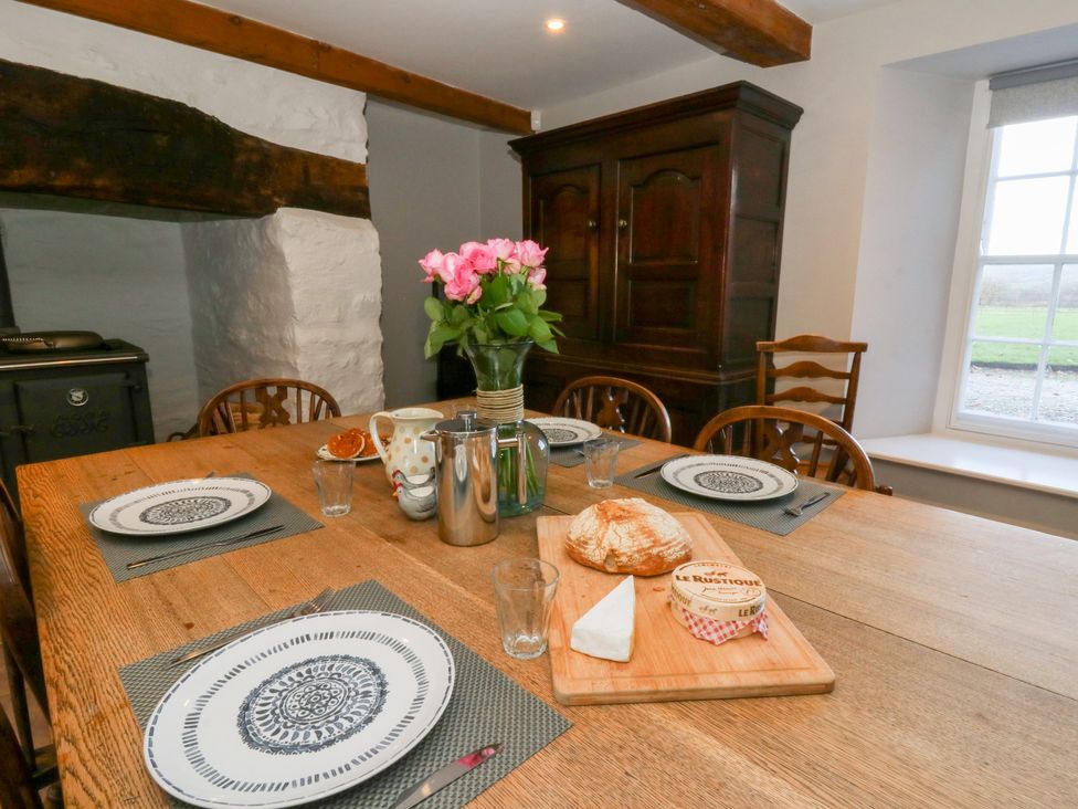 A dining room with a table set for a meal at Secret Garden Cottage in Ciliau Aeron near Aberaeron