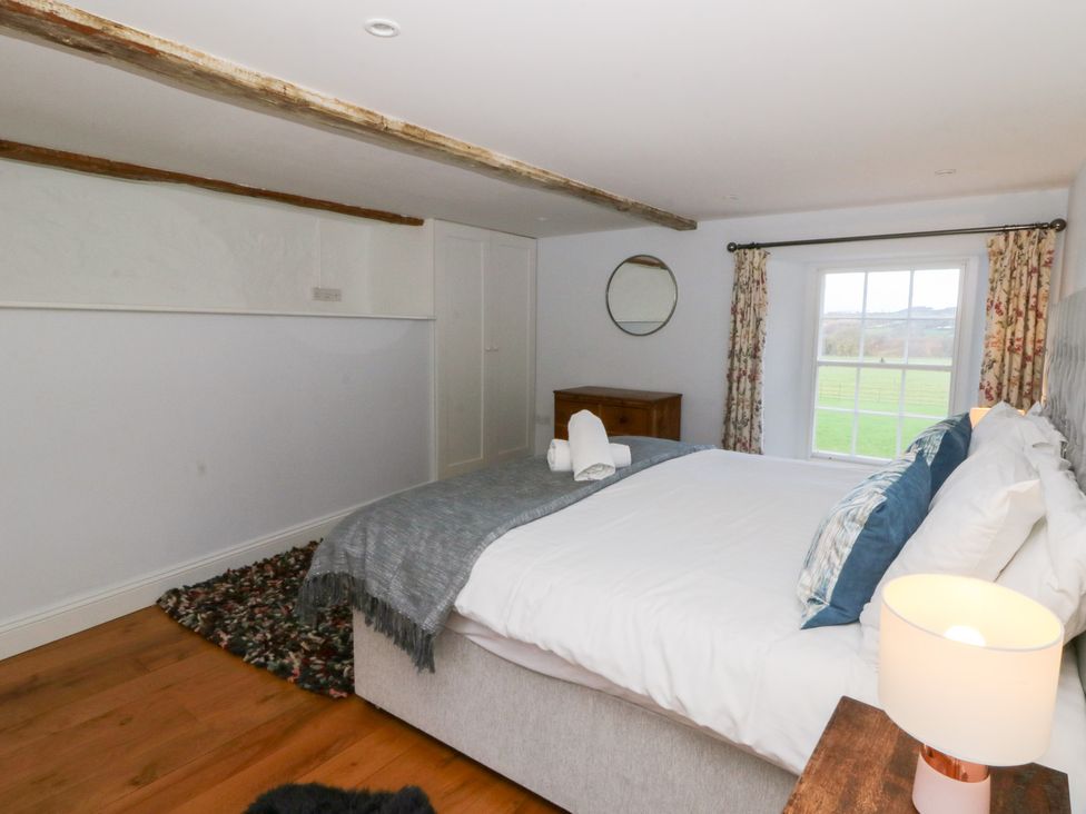 A bedroom with a bed and dresser at Secret Garden Cottage in Ciliau Aeron near Aberaeron