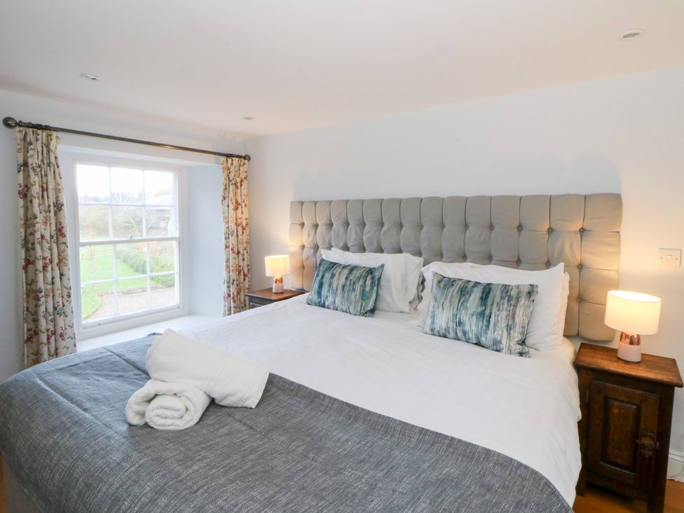A bedroom with a large bed and bedside tables at Secret Garden Cottage in Ciliau Aeron near Aberaeron