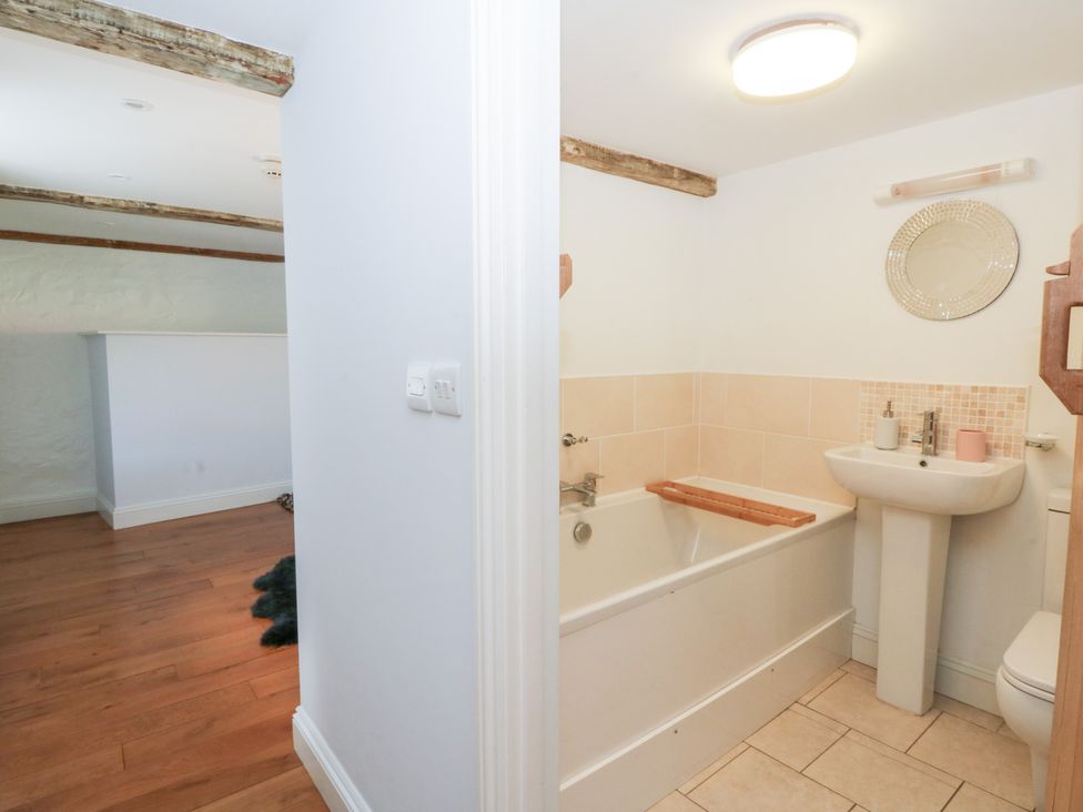 A bathroom with a bathtub and a sink at Secret Garden Cottage in Ciliau Aeron near Aberaeron