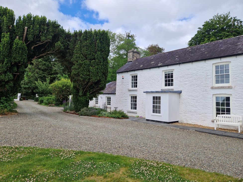 A house with trees and a gravel path at Secret Garden Cottage Ciliau Aeron near Aberaeron