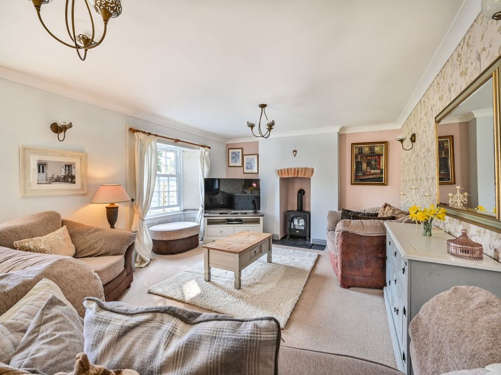 A living room with a sofa and a fireplace at The Old Farm House near Pelynt
