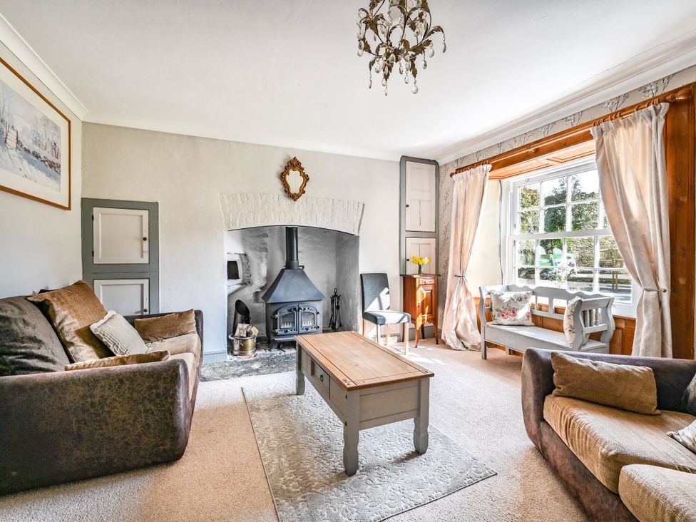 A living room with a fireplace and coffee table at The Old Farm House near Pelynt