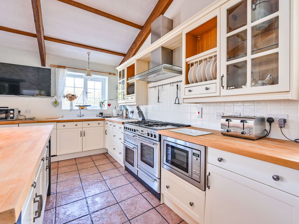 A kitchen with cabinets and appliances at The Old Farm House near Pelynt