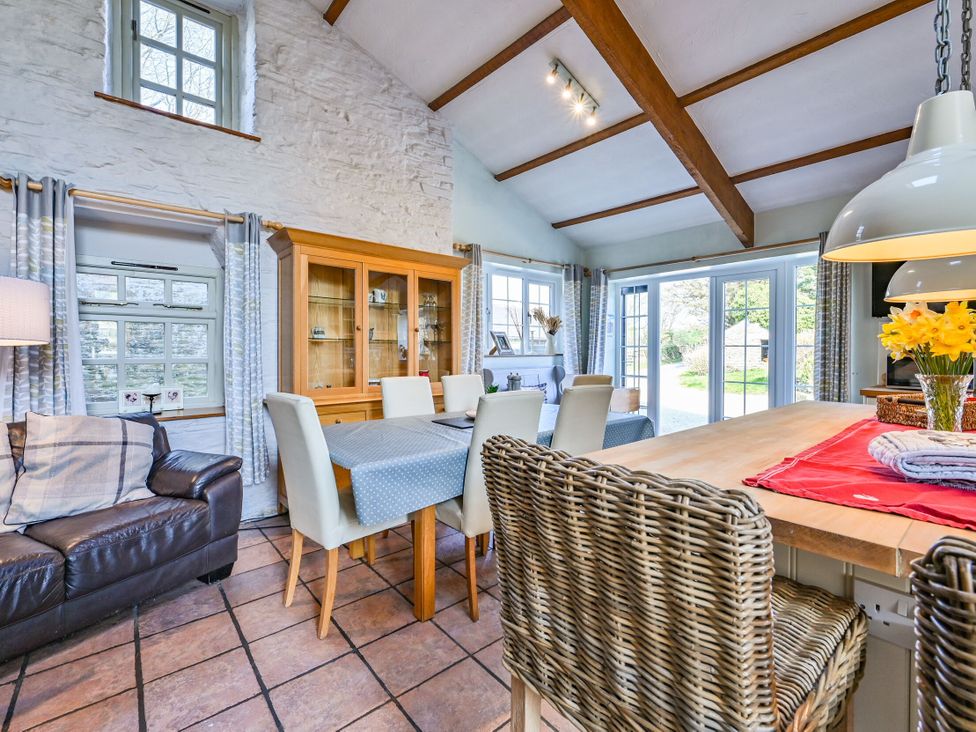 A dining room with a table and chairs at The Old Farm House near Pelynt