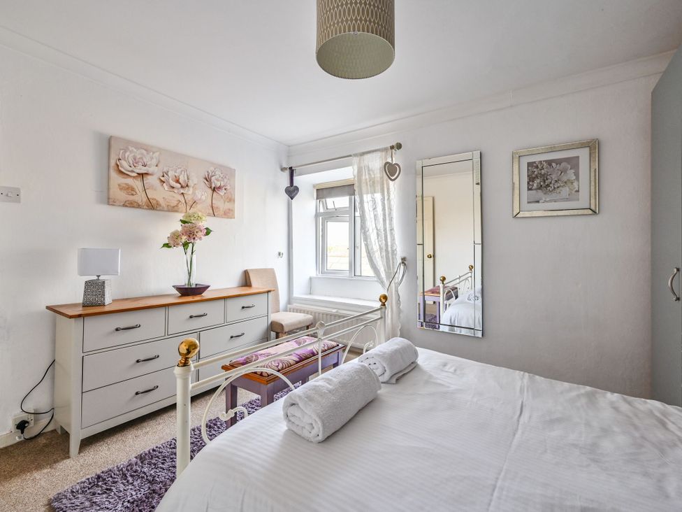 A bedroom with a bed and dresser at The Old Farm House near Pelynt