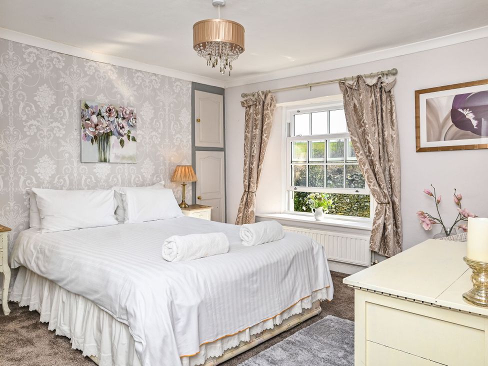 A bedroom with a bed and decorative items at The Old Farm House near Pelynt