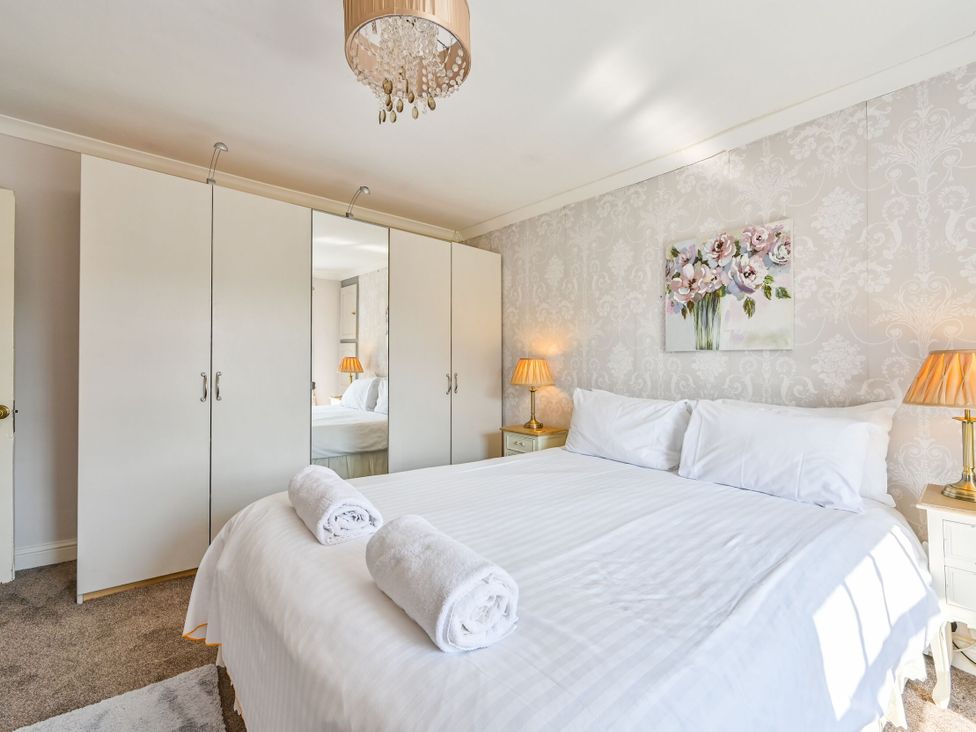 A bedroom with a bed and wardrobe at The Old Farm House near Pelynt