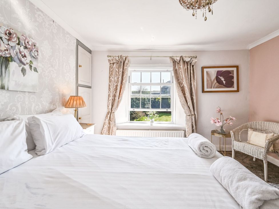 A bedroom with a bed and window at The Old Farm House near Pelynt
