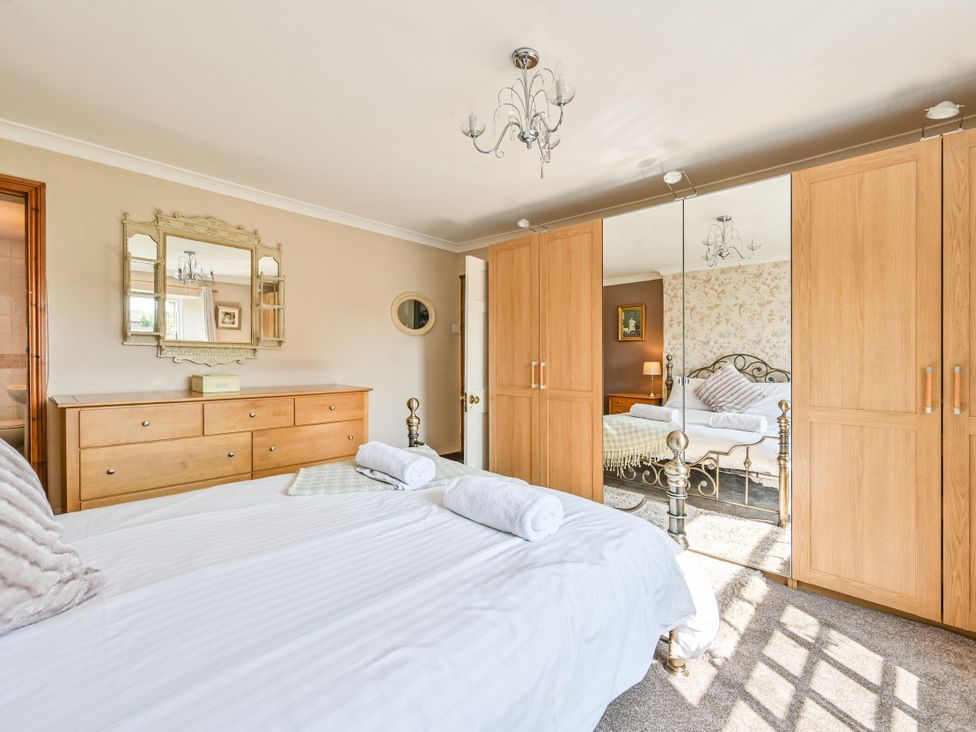 A bedroom with a double bed and wooden furniture at The Old Farm House near Pelynt