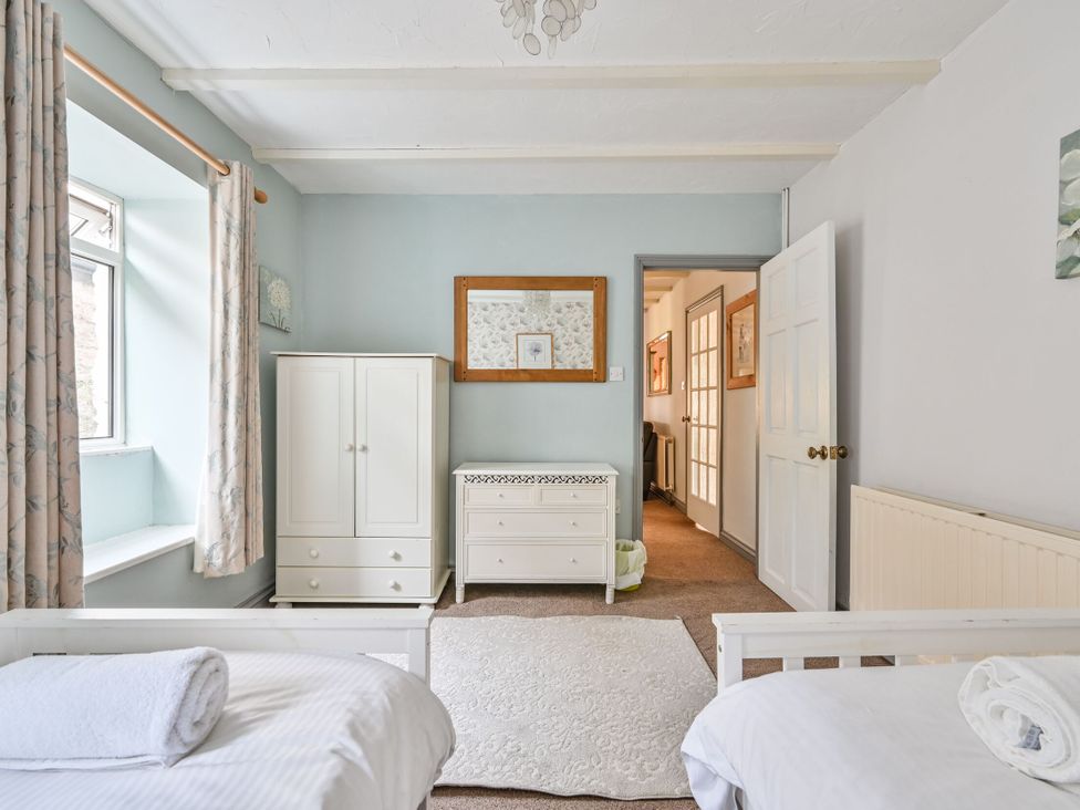 A bedroom with a bed and wardrobe at The Old Farm House near Pelynt