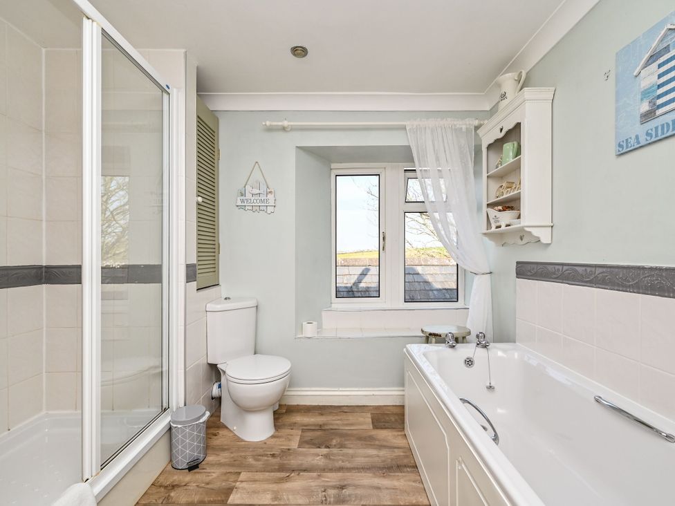 A bathroom with a shower, bathtub, and toilet at The Old Farm House near Pelynt