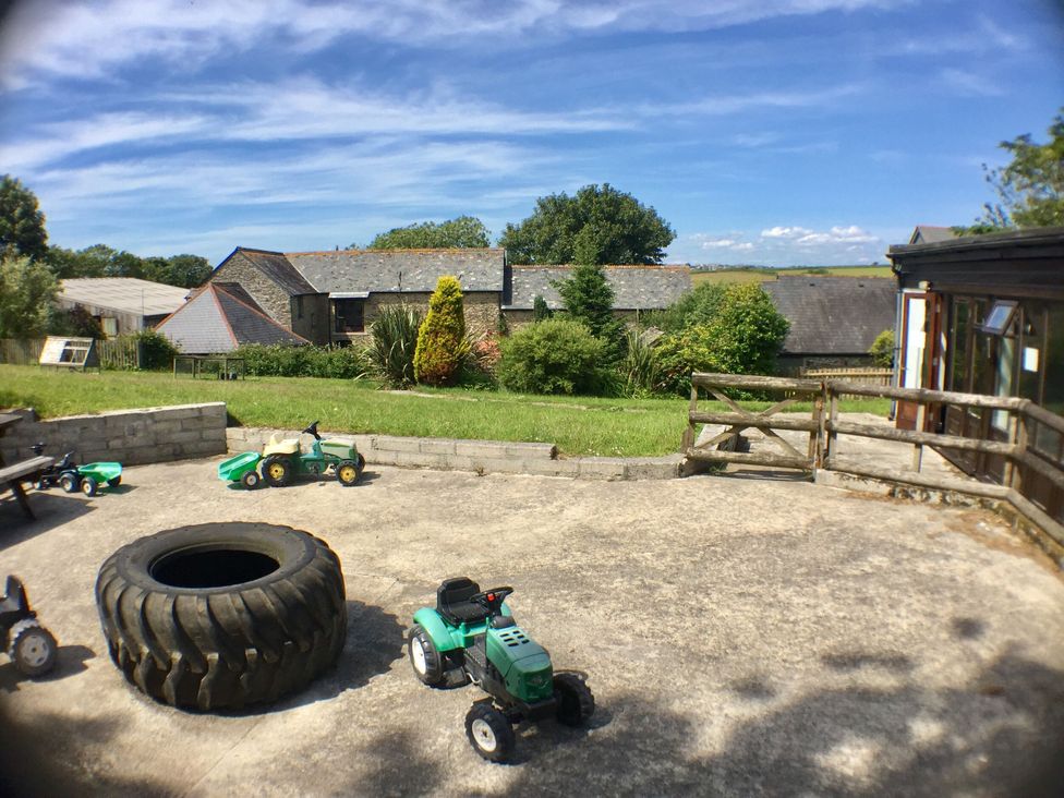 A yard with toy tractors and a tire at The Old Farm House near Pelynt