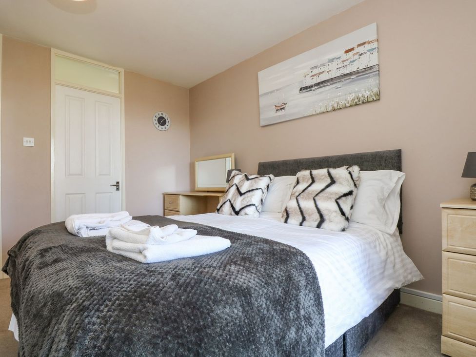 A bedroom with a bed and mirror at Valley Lodge 61 Callington