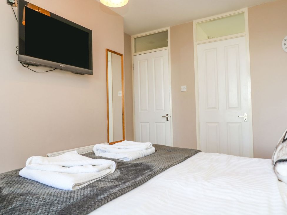 A bedroom with a television and a mirror at Valley Lodge 61 in Callington