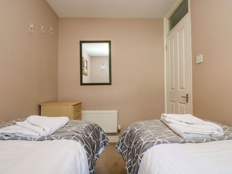 A bedroom with two beds and a mirror at Valley Lodge 61 Callington